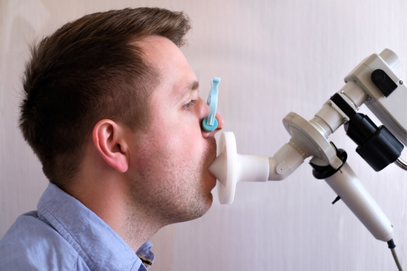 Young man testing breathing function by spirometry